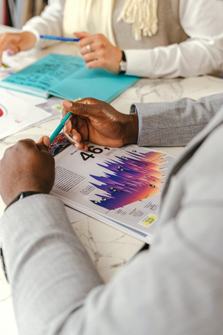 Individuals reviewing graphs during an in-depth business meeting, highlighting analysis.